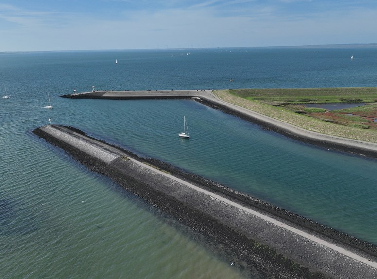 Luchtfoto van strekdammen en zeilboten op het water in Zeeland