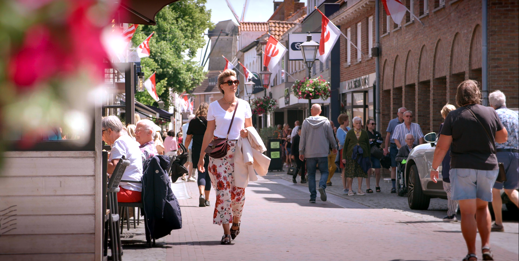 Frau, die an Straßencafés in einer zeeländischen Stadt vorbeigeht