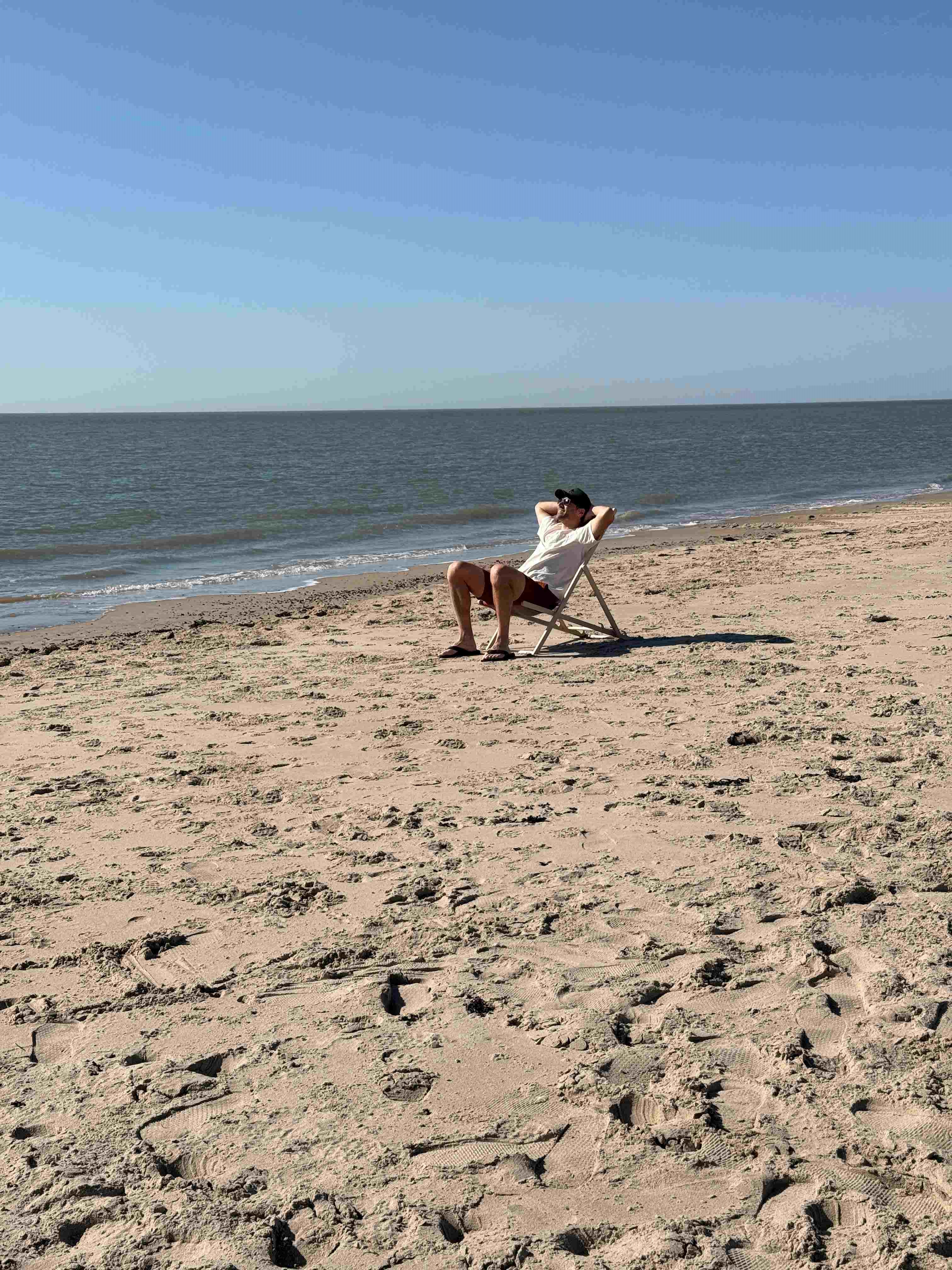 Man op strandstoel op het strand