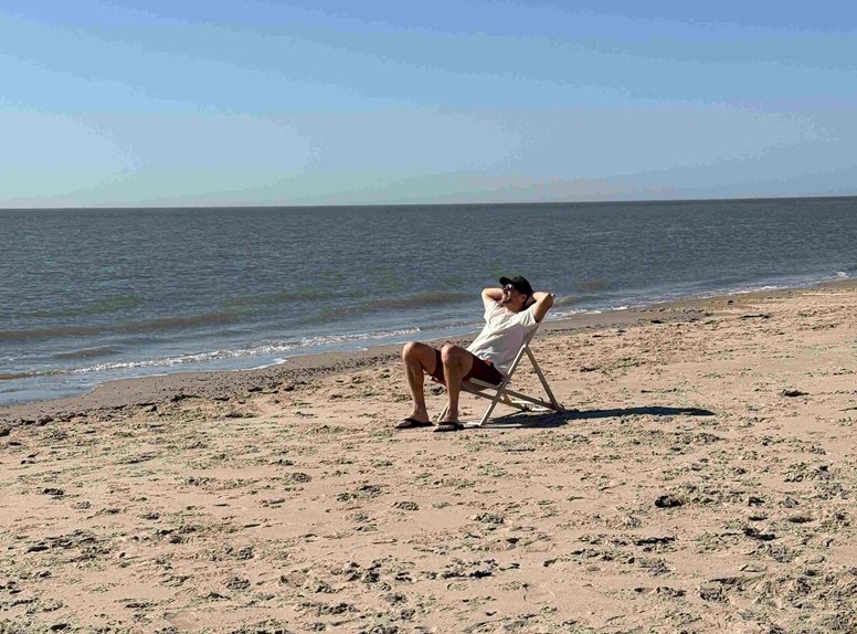 Man op strandstoel op het strand