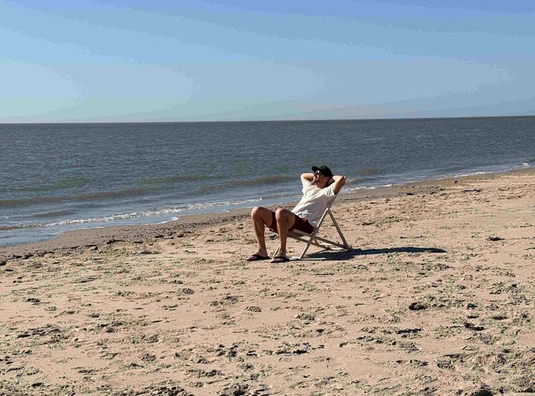 Mann auf einem Liegestuhl am Strand