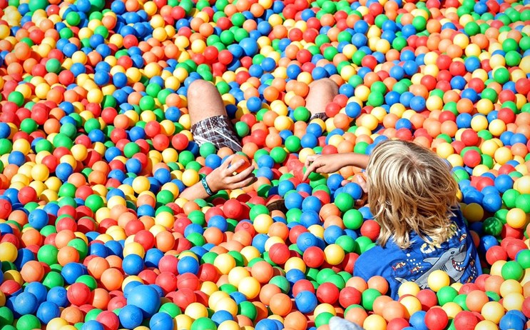 Spelende kinderen in een kleurrijke ballenbak. Leuke attractietips in Zeeland voor kinderen en volwassenen. 