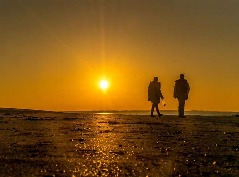 strandwandeling ondergaande zon