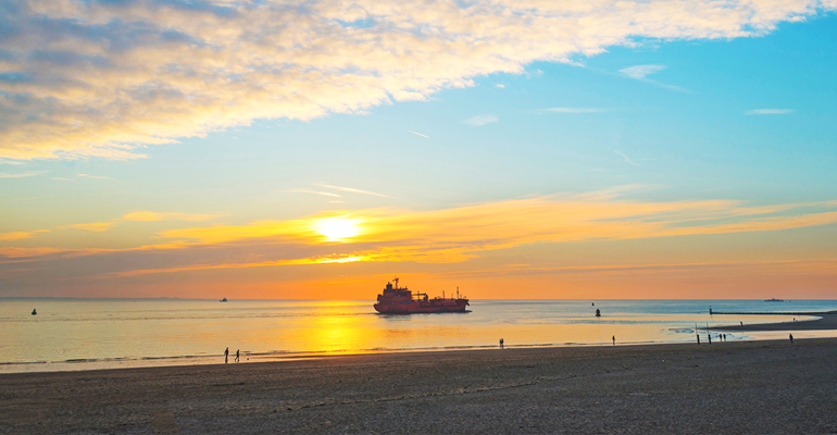 Boten langs zien varen vanaf het strand of boulevard. Zeeland, niet normaal mooi