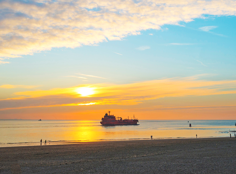 Boten langs zien varen vanaf het strand of boulevard. Zeeland, niet normaal mooi