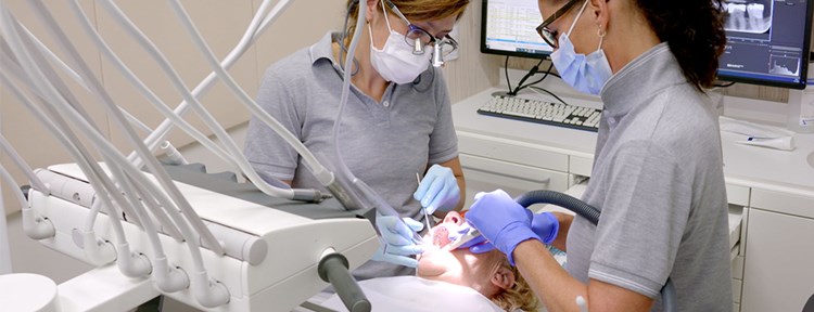 Tandarts en tandartsassistente voeren periodieke controle uit bij patiënt in tandartspraktijk in Zeeland