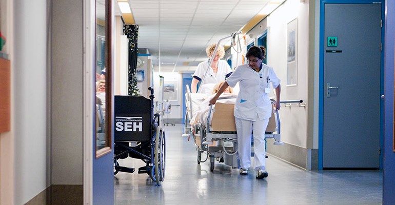 Verzorgende met cliënt op de gang van het woonzorgcentrum WVO Zorg. Werken in de Zorg en Welzijn sector bied zorgprofessionals volop kansen!