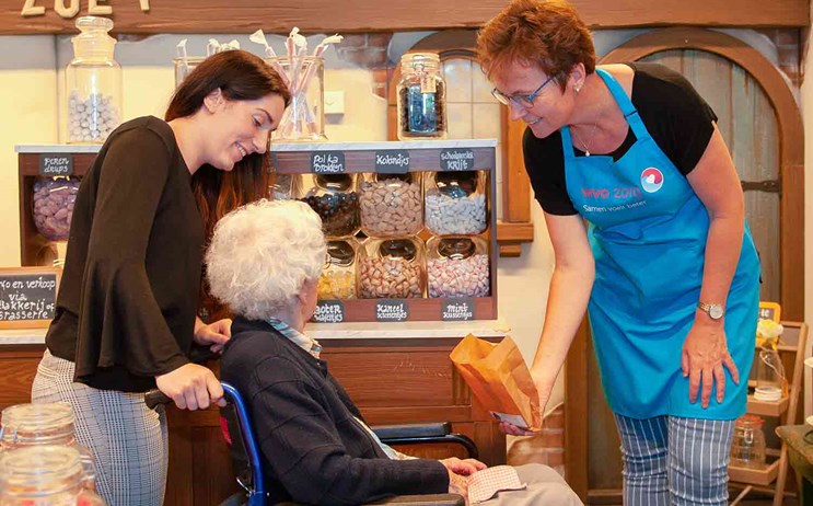 Oudere vrouw in snoepwinkel bij WVO Zorg