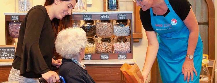 Oudere vrouw in snoepwinkel bij WVO Zorg