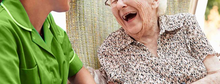 Lachende oude dame die ouderenzorg ontvangt van allevo thuiszorg