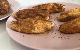 Rijzen maakt deel uit van ons bolus recept. Ongebakken bolussen zo groot als een worstje gerold in suiker op een roze bord.